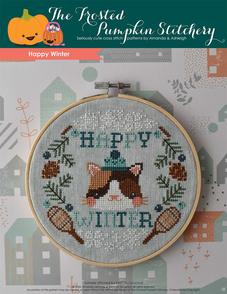  Happy Winter counted cross stitch pattern. This pattern features a cat wearing a winter cap surrounded by the words "Happy Winter," pine boughs, pine cones, snowshoes, snowflakes and juniper berries.