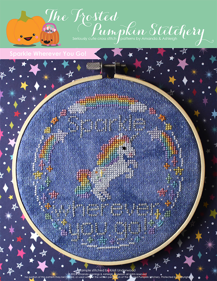 Sparkle Wherever You Go! A Unicorn with a rainbow mane and tail stands on his hind legs surrounded by rainbows and stars. Stitched on blue fabric. 