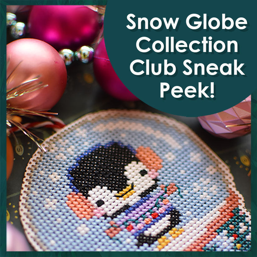 Snow Globe Collection Pattern Sneak Peek. Picture depicts a penguin wearing ear muffs, mittens and a sweater. The penguin is holding a string of lights and is surrounded by ornaments.