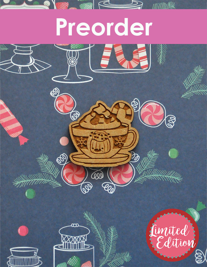 Candy cane hot cocoa mug wooden needleminder on a blue background.