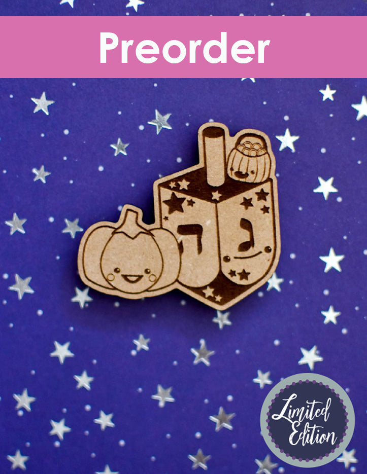 Wooden needleminder with a design of a dreidel and pumpkin on a blue background with star patterns, labeled 'Preorder Limited Edition'.