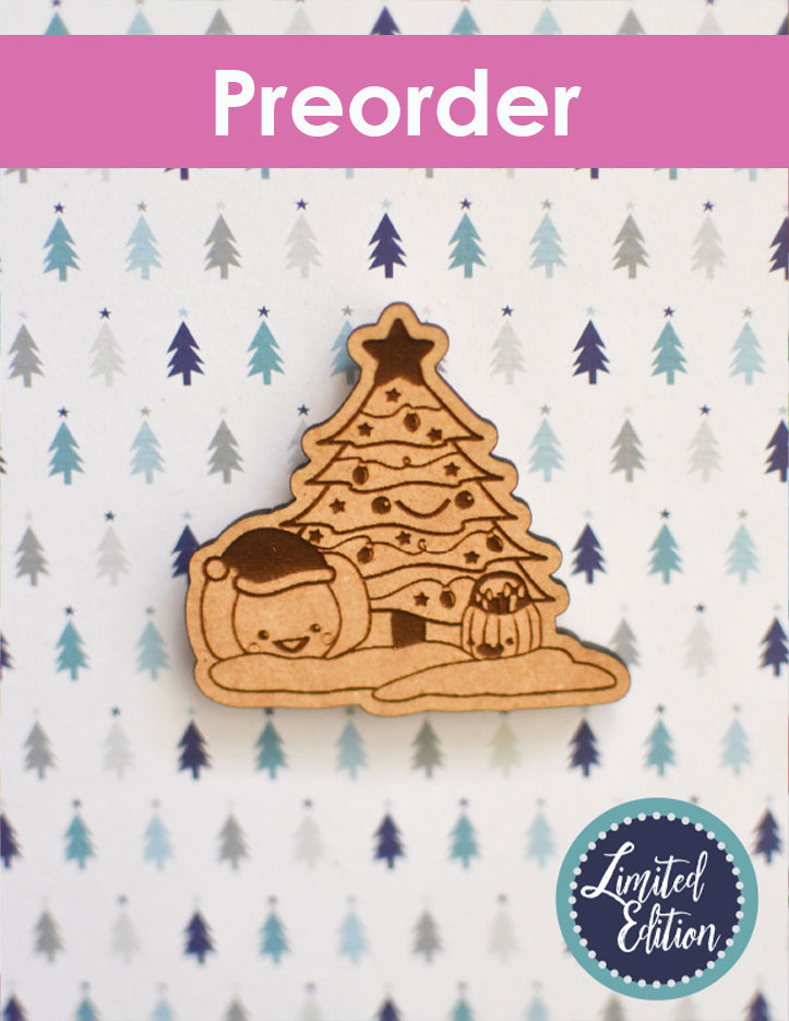 Wooden Christmas tree-shaped needleminder with a limited edition label on a tree patterned background