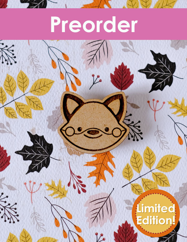Wooden fox-shaped needleminder on a  autumn leaf paper background and the word 'Preorder' at the top.