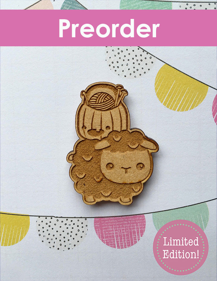 Wooden sheep needleminder with a pumpkin on top oh him with a pink banner above it on a patterned background