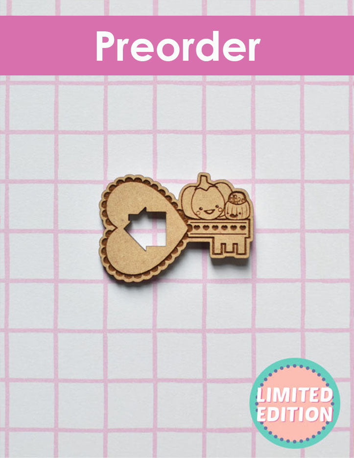 Wooden key-shaped needleminder with heart cutout on a grid background, labeled 'Preorder Limited Edition'.