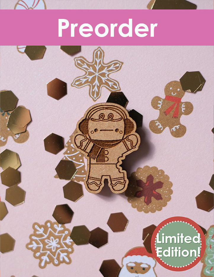 Preorder limited edition gingerbread man needleminder design on a decorative background with snowflakes and cookies.
