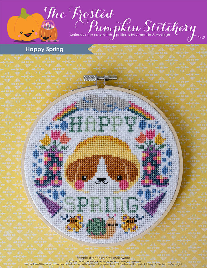 Happy Spring cross stitch pattern. Image of an embroidery hoop with a dog in a rain hat surrounded by rain boots, rainbows, butterflies, umbrellas, a snail and cloud.