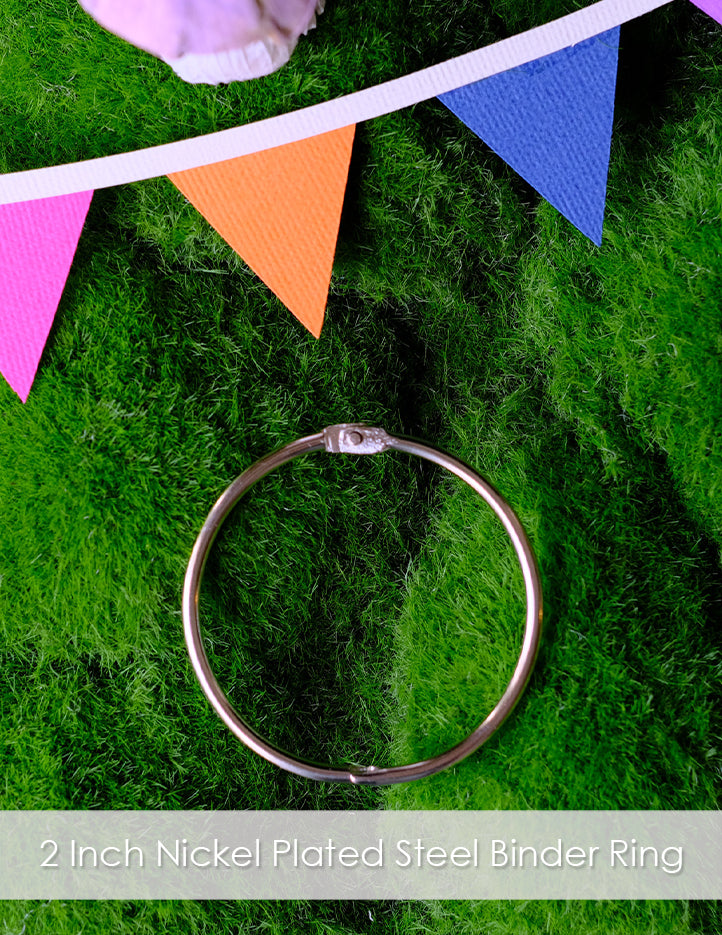 A 2 Inch nickel plated steel binder ring listing. The image of the ring is a flat lay with it laid on faux grass and surrounded by bunting and a mushroom.