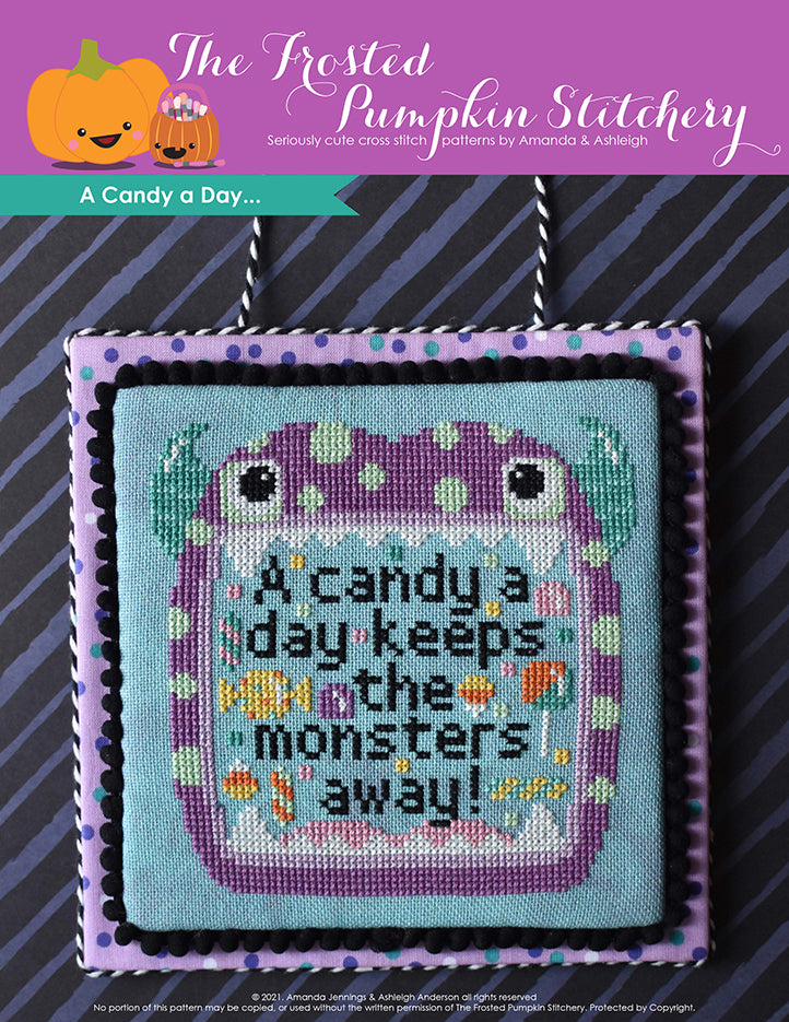 A candy a day keeps the monsters away. A purple monster with aqua horns and a pale green polka dots opens his mouth with text inside that reads "A candy a day keeps the monsters away!" 