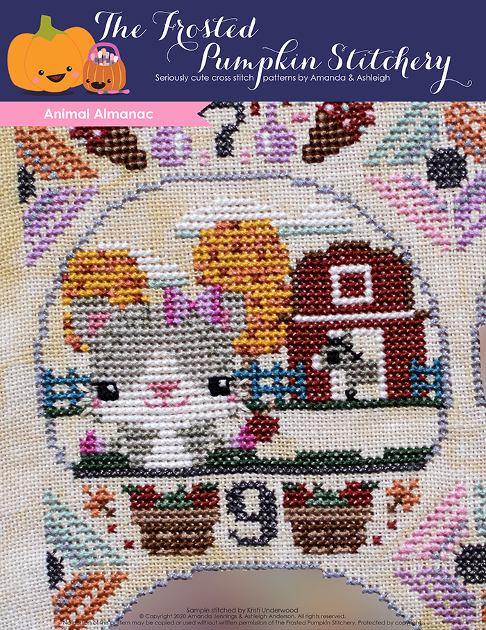 Animal Almanac Cross Stitch Pattern Cover. Image of cat wearing a bow and mittens holding an apple in front of a barn. The barn is surrounded by fall colored trees and inside the barn is a donkey.