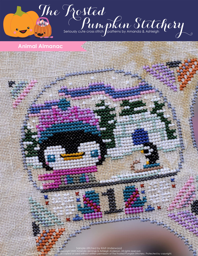 Animal Almanac Cross Stitch Pattern Cover. Image of a penguin dressed in a knit hat in front of an igloo. The Aurora Borealis is in the background. 