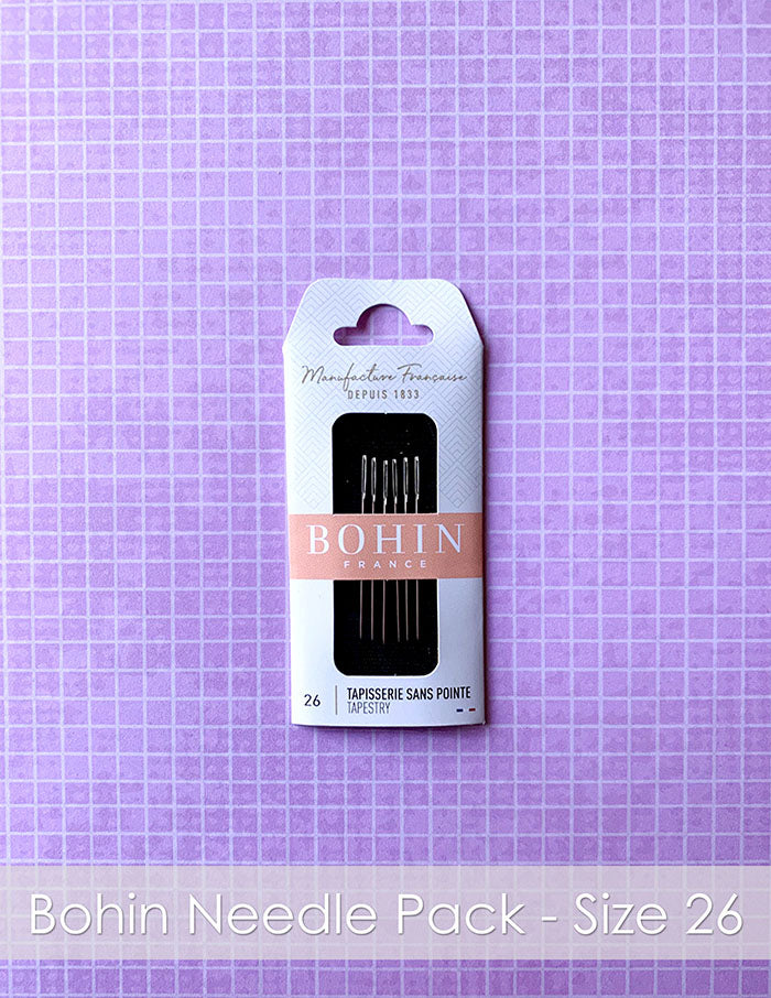 Bohin France Needle Pack Size 26. A package of tapestry needles on a pink plaid background