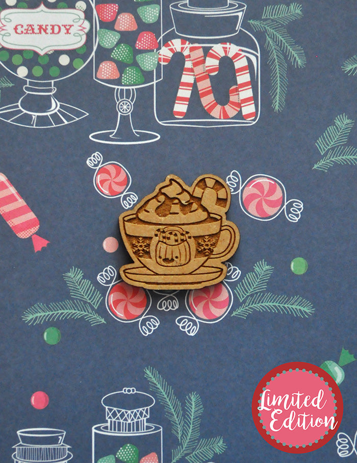 Image of a wooden needleminder with a coffee cup with a candy cane. 