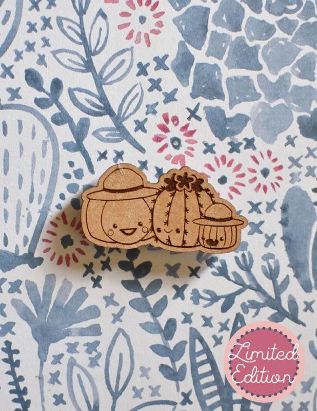Image of a wooden needleminder with Sugarloaf and Jack (TFPS mascots who are pumpkins) hanging out with a barrel cactus. The cactus has a flower and a big smile.