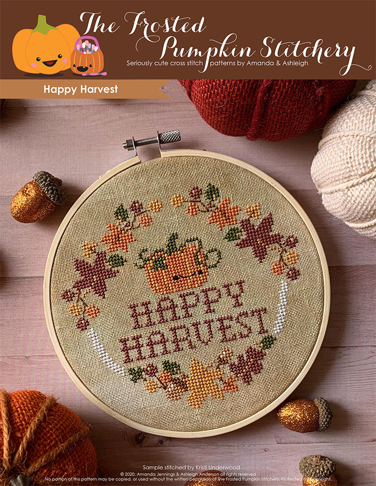 Happy Harvest cross stitch cover image. Picture of a pumpkin surrounded by autumn leaves, acorns, berries and the words "Happy Harvest."