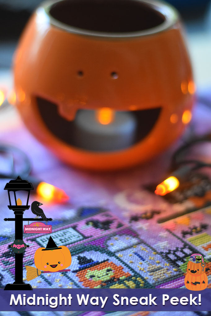 Midnight Way sneak peek. A witch is working in the broom shop, text reads "Midnight Way Sneak Peek!" On top of the stitched project is a pumpkin candle holder.