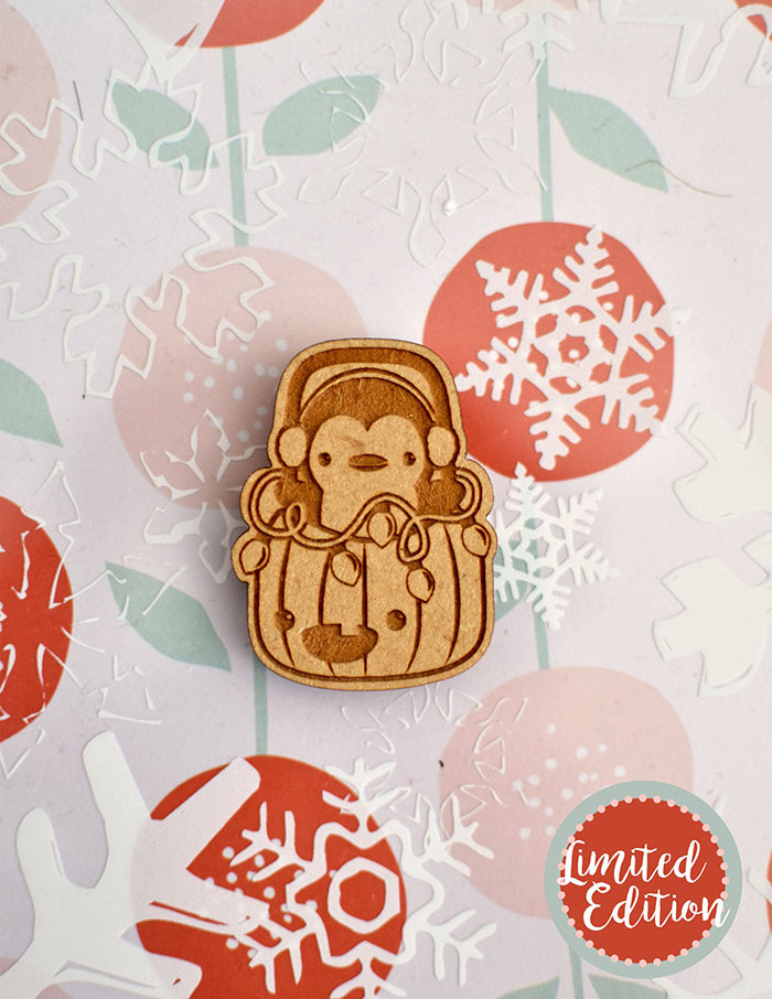 Image of a wooden needleminder with a penguin popping out of a pumpkin.