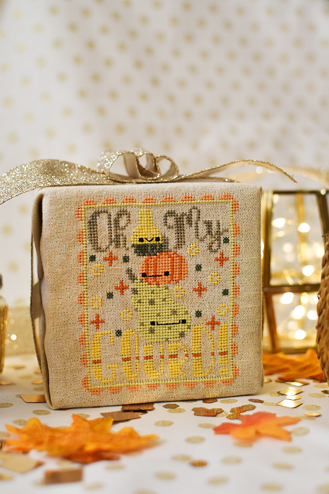 Oh My Gourd counted cross stitch pattern with a stack of three gourds all with faces. The text around them reads "oh my gourd".