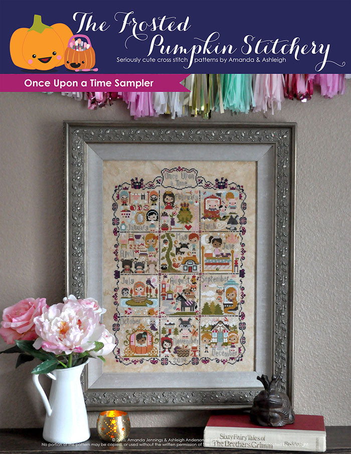 Once Upon a Time Sampler counted cross stitch pattern. Stories include Snow White, Frog Prince, Three Little Pigs and more. Framed piece is against a neutral wall with peonies in a vase in front of it.