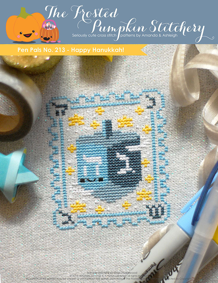 Pen Pals No 213 Happy Hannukah counted cross stitch pattern. A blue dreidel with a kawaii face surrounded by stars.