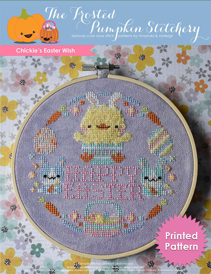 Chickie's Easter Wish Cross Stitch Pattern. This pattern is finished in a 6" embroidery hoop and features a fuzzy chick hatching from an Easter egg surrounded by pastel bunnies, carrots, flowers, eggs, Easter basket and the phrase "Happy Easter." Text reads "Printed Pattern."