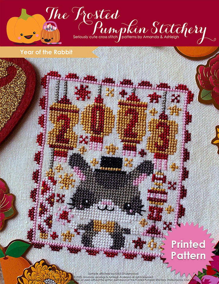 Year of the Rabbit Chinese zodiac counted cross stitch pattern features customizable year lanterns, a rabbit and a color palette of red and gold. Printed pattern.
