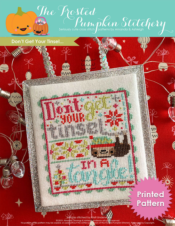 Don't Get Your Tinsel counted cross stitch pattern. Text reads "Don't get your tinsel in a tangle" with a sloth. Printed Pattern.