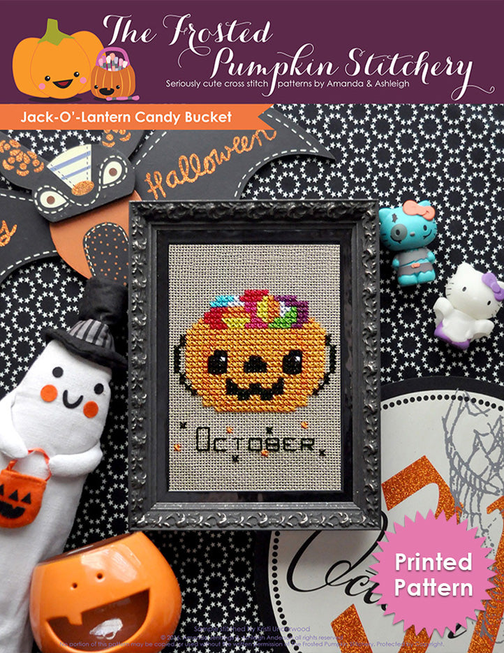 Jack'-O-Lantern Candy Bucket counted cross stitch pattern. A candy bucket filled with candy in a black frame.