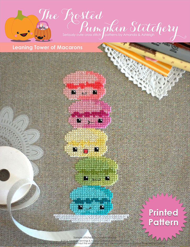 Leaning tower of macarons. Five rainbow macarons with kawaii faces are stacked on a white dish. Printed Chart.