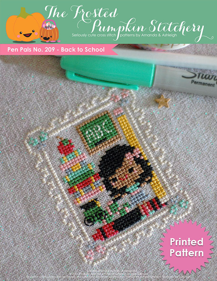 Pen Pals No 209 Back to School counted cross stitch pattern. A girl with brown skin and dark hair stands with a caterpillar wearing glasses and a chalk board that says ABC. Printed Pattern.