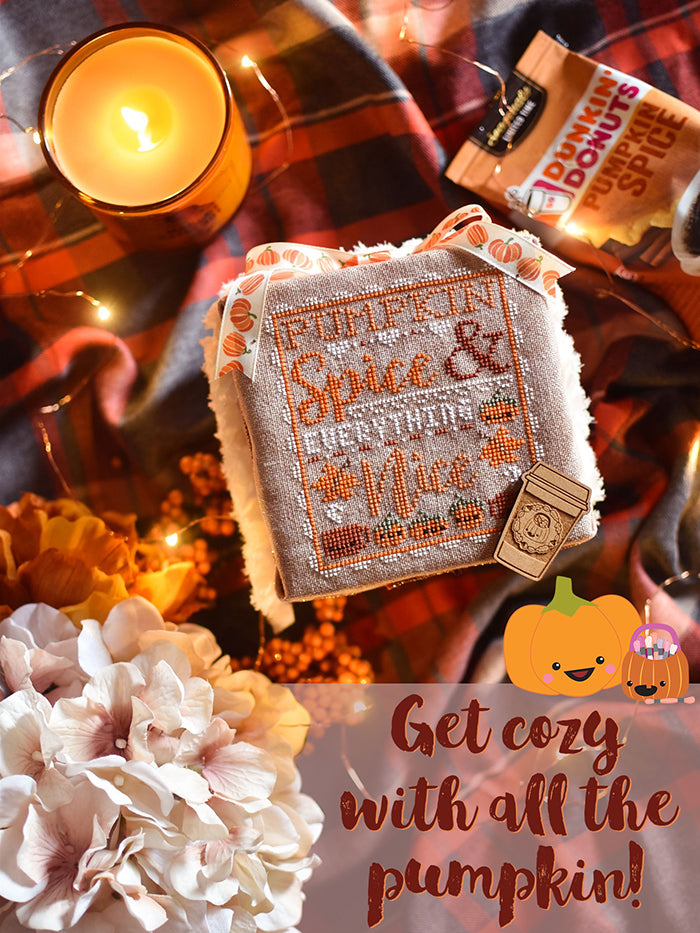 Pumpkin Spice and Everything Nice counted cross stitch pattern cozy flat lay. Cross stitch pattern is laying on a plaid blanket surrounded by candles and a bag of pumpkin spice coffee. Text reads "get cozy with all the pumpkin".