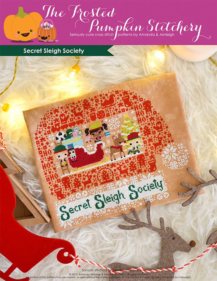 Secret Sleigh Society counted cross stitch pattern. Three elves surround Santa's sleigh with the text below "Secret Sleigh Society".