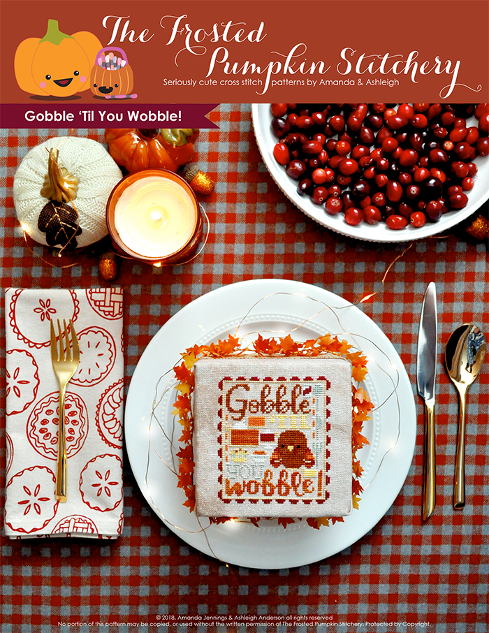 Gobble 'Til You Wobble Thanksgiving counted cross stitch pattern. A finished cross stitch pattern in a plate with place settings and cranberries. Text reads "Gobble Til You Wobble"