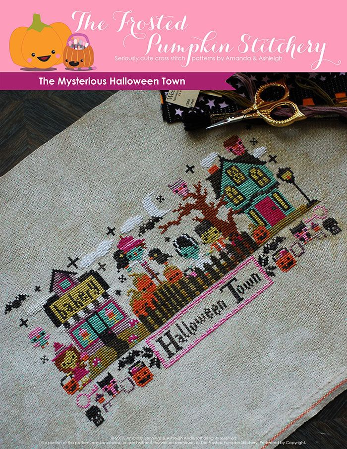 Mysterious Halloween Town counted cross stitch pattern. Bottom text says Halloween Town. The town has a witch in front of a bakery, a scarecrow among pumpkins, Frankenstein and his Bride next to a haunted house.