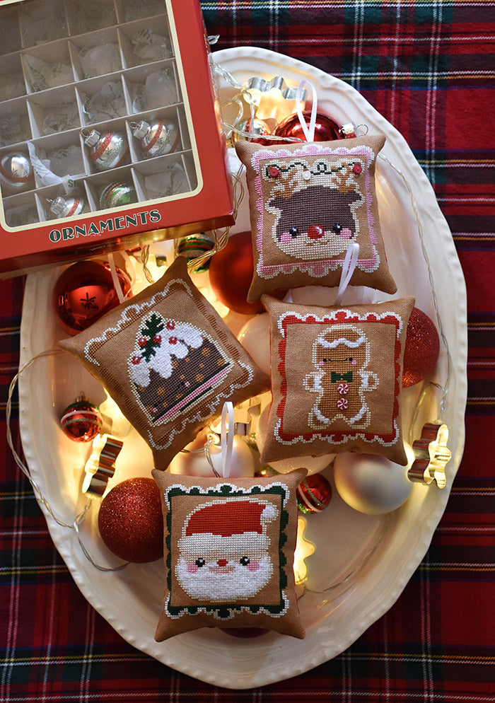 Cookies for Santa counted cross stitch pattern. Chubby ornaments are in a dish on a plaid tablecloth.